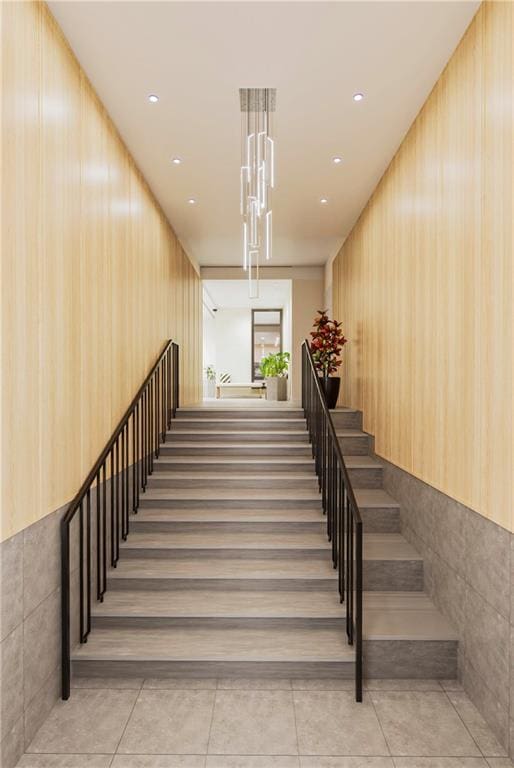 stairs featuring tile patterned flooring and tile walls