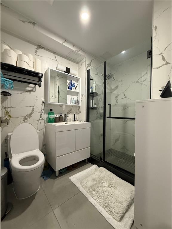 bathroom featuring toilet, vanity, tile walls, and walk in shower