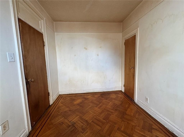 hallway featuring dark parquet floors and a textured ceiling