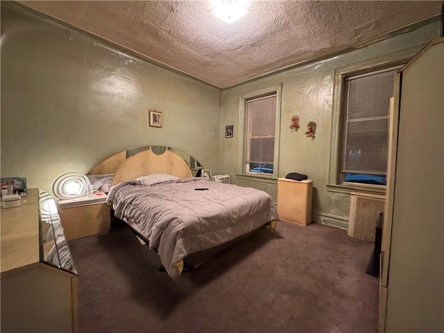 bedroom featuring a textured ceiling and dark colored carpet