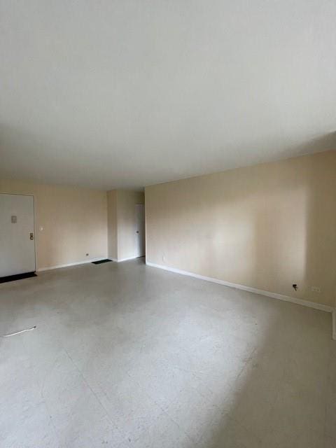 spare room featuring tile patterned floors and baseboards