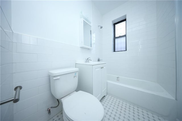 bathroom featuring vanity, tile walls, and toilet