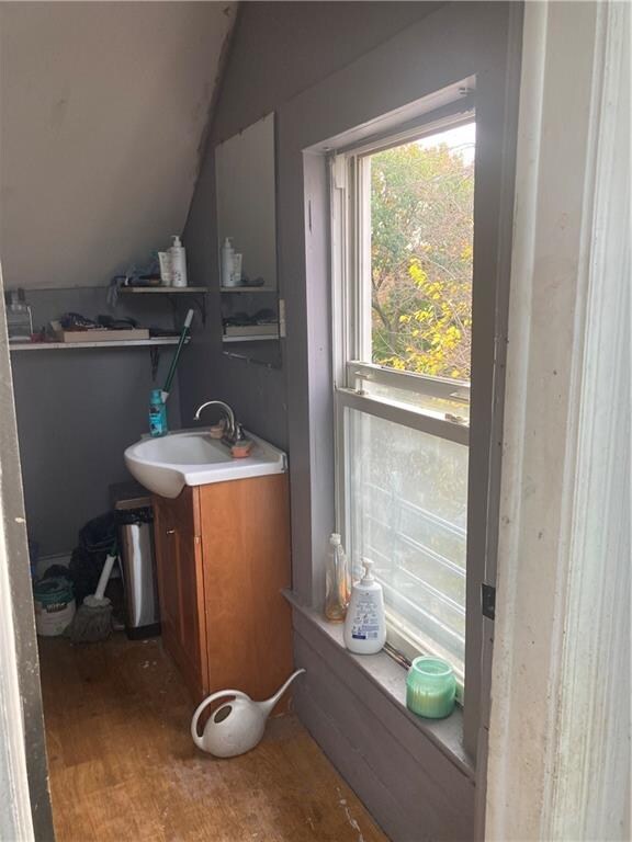 bathroom featuring lofted ceiling, wood-type flooring, and vanity