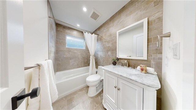 full bathroom with tile walls, vanity, shower / bath combo, and toilet