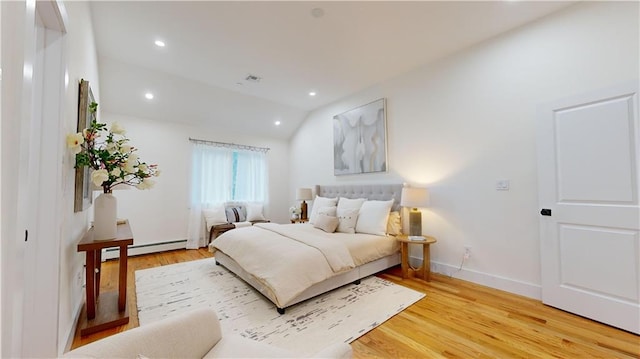 bedroom with wood-type flooring, lofted ceiling, and baseboard heating