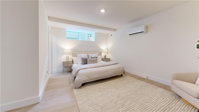 bedroom featuring a wall unit AC and light hardwood / wood-style flooring