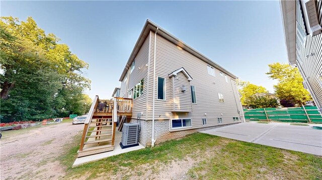 view of home's exterior featuring cooling unit and a wooden deck