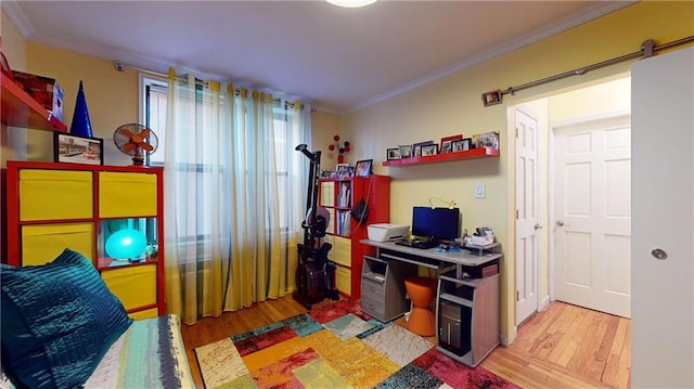 home office with light hardwood / wood-style floors and ornamental molding