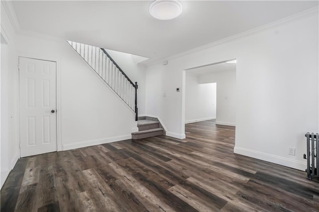 unfurnished living room featuring crown molding and dark wood-type flooring