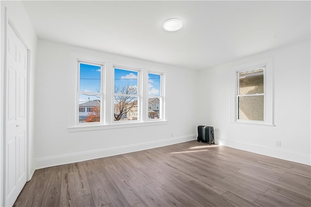 spare room with radiator and hardwood / wood-style floors