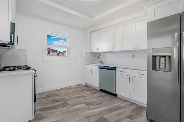 kitchen with backsplash, stainless steel appliances, sink, and white cabinets