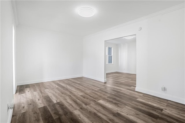 spare room with dark hardwood / wood-style flooring and crown molding