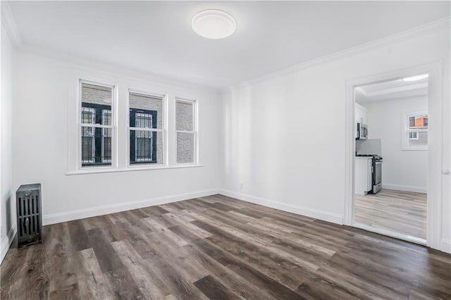 empty room featuring dark wood-type flooring and crown molding