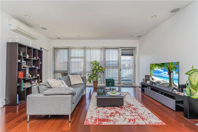 living room with dark wood-type flooring and a wall mounted air conditioner