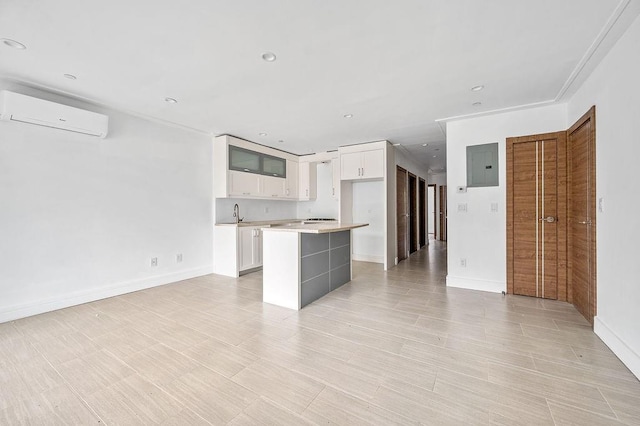 2335 Bath Ave Unit 1A, Brooklyn, NY 11214 - kitchen with a wall mounted air conditioner, electric panel, a center island, white cabinets, and light countertops