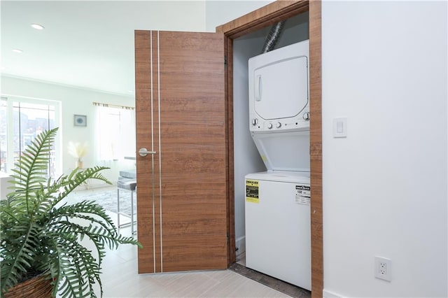 laundry room featuring stacked washer and dryer, laundry area, recessed lighting, and light tile patterned floors