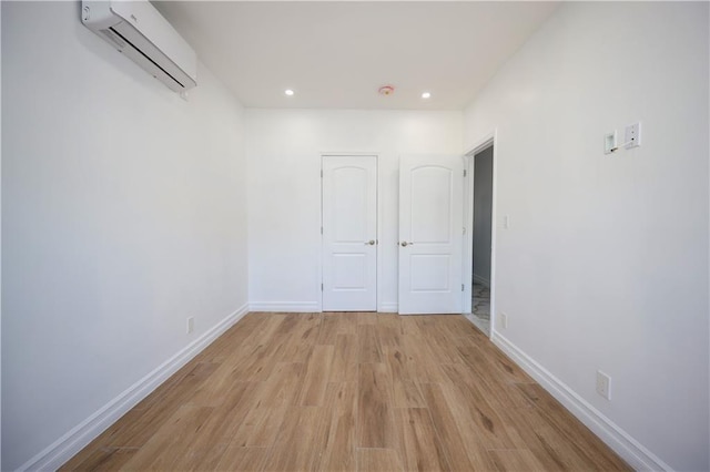 interior space with light wood-type flooring and a wall mounted AC