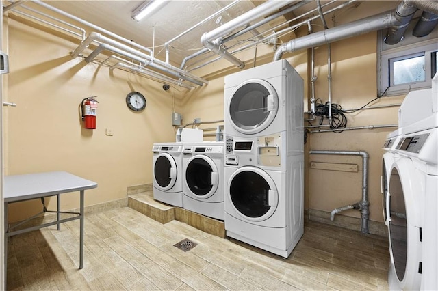 washroom featuring stacked washing maching and dryer, hardwood / wood-style floors, and independent washer and dryer