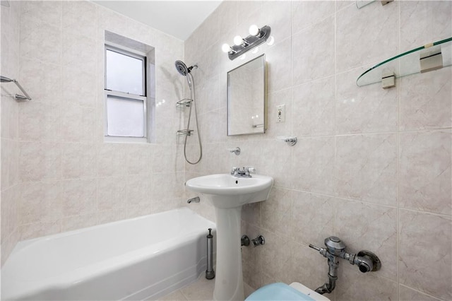 bathroom featuring tiled shower / bath and tile walls