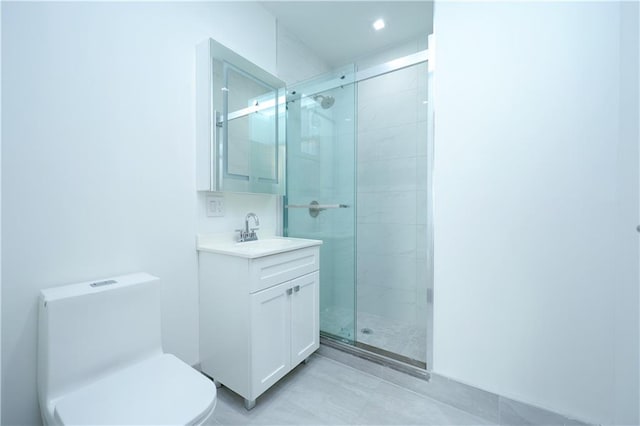 bathroom featuring toilet, a stall shower, and vanity