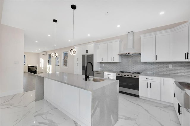 kitchen with white cabinets, stainless steel appliances, wall chimney exhaust hood, and an island with sink