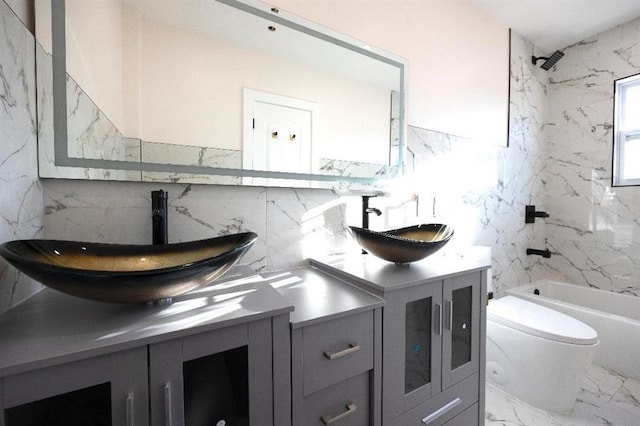 full bathroom featuring tile walls, washtub / shower combination, vanity, and toilet