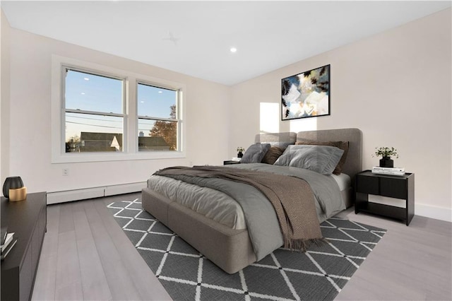 bedroom featuring baseboards, baseboard heating, wood finished floors, and recessed lighting