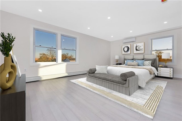 bedroom featuring baseboard heating, light wood-type flooring, multiple windows, and a wall mounted air conditioner