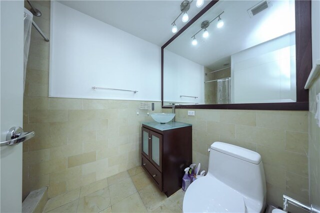 bathroom featuring vanity, curtained shower, toilet, and tile walls