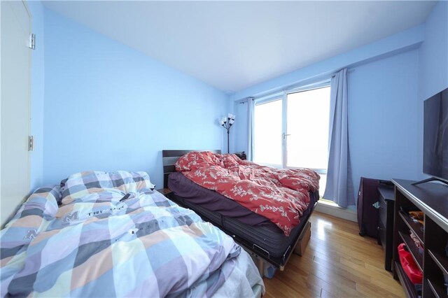 bedroom featuring hardwood / wood-style floors and lofted ceiling