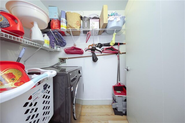 washroom with light hardwood / wood-style floors and washing machine and dryer