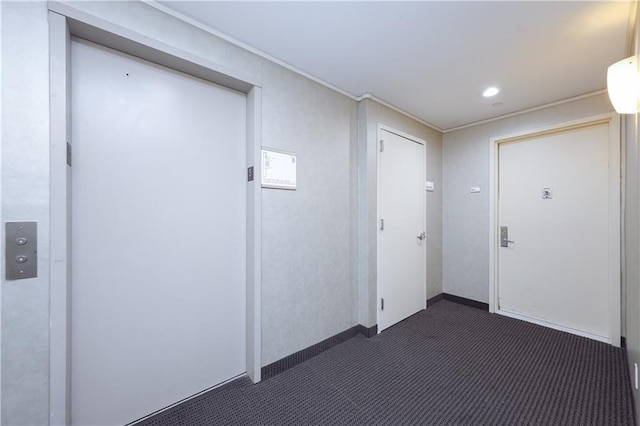 interior space featuring dark colored carpet, recessed lighting, and elevator