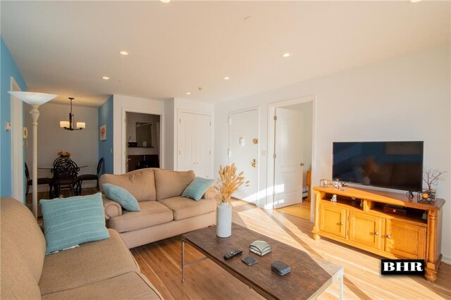 living room with a notable chandelier and light hardwood / wood-style floors