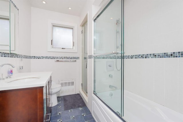 full bathroom with tile patterned floors, vanity, shower / bath combination with glass door, tile walls, and toilet