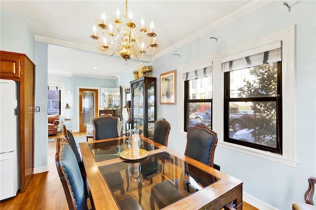 dining room featuring wood-type flooring, crown molding, and a notable chandelier