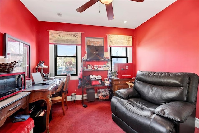 carpeted home office featuring ceiling fan