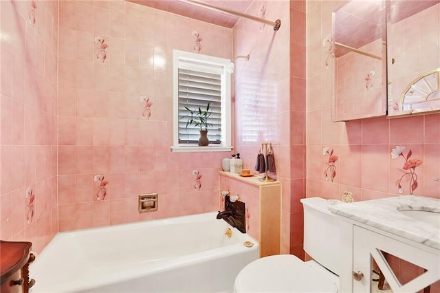 full bathroom with toilet, tile walls, tiled shower / bath, and vanity