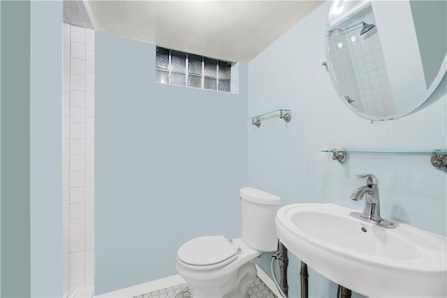 bathroom featuring a shower, sink, and toilet