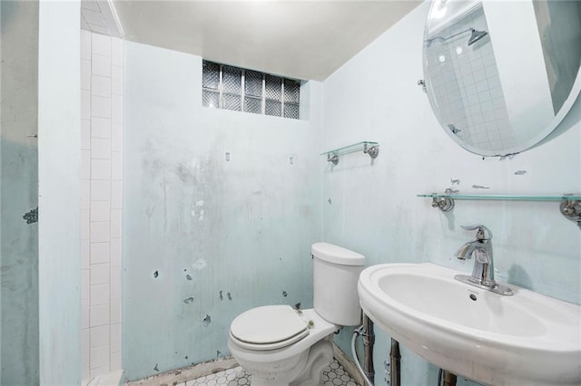 bathroom with toilet, tile patterned flooring, and sink