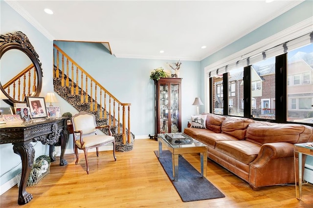 living room featuring light wood-type flooring, plenty of natural light, and ornamental molding