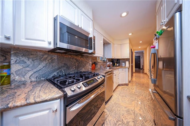 kitchen with a sink, white cabinetry, recessed lighting, appliances with stainless steel finishes, and decorative backsplash