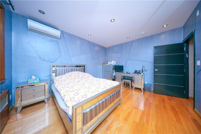 bedroom featuring recessed lighting, an AC wall unit, and light wood-type flooring