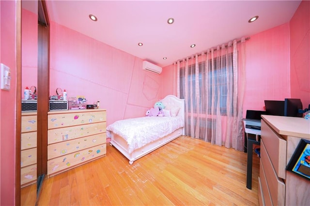 bedroom featuring recessed lighting, a wall mounted AC, and wood finished floors