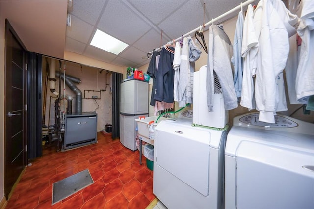 laundry area featuring water heater, laundry area, a heating unit, and separate washer and dryer