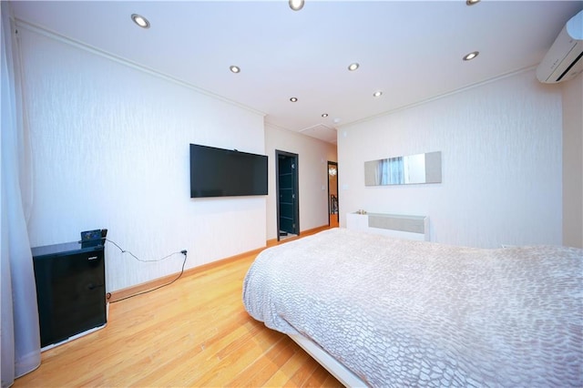 bedroom featuring recessed lighting, a wall unit AC, and wood finished floors