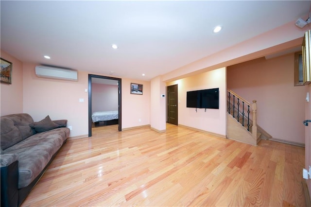 living room featuring stairway, recessed lighting, light wood-style floors, and a wall mounted air conditioner