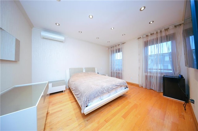 bedroom with crown molding, recessed lighting, light wood finished floors, and a wall mounted AC