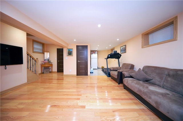 living area featuring recessed lighting, baseboards, stairs, and light wood-style floors