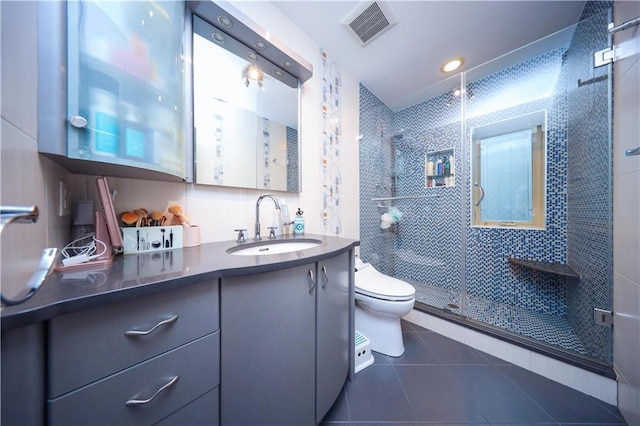 full bathroom featuring vanity, visible vents, a shower stall, tile patterned floors, and toilet