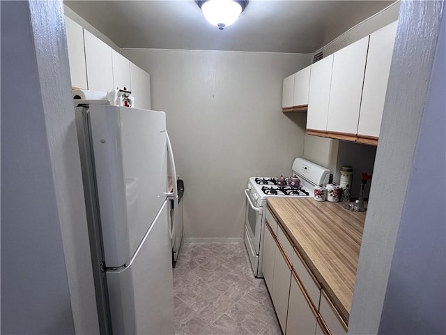 kitchen featuring white appliances and white cabinets